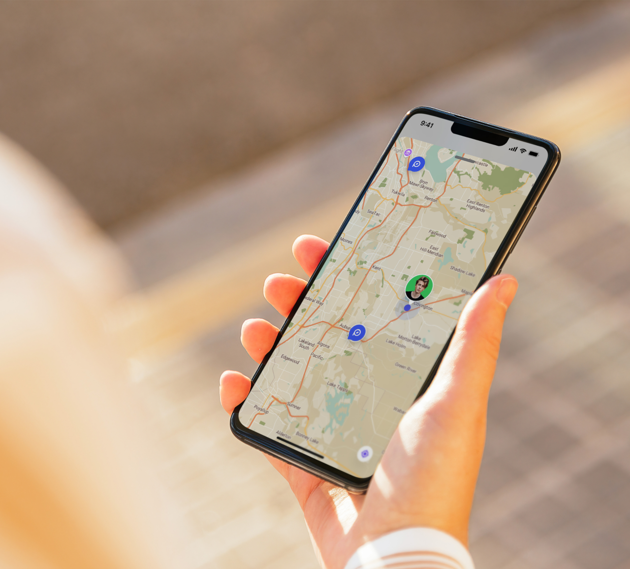 Hand holding a smartphone displaying a live tracking map